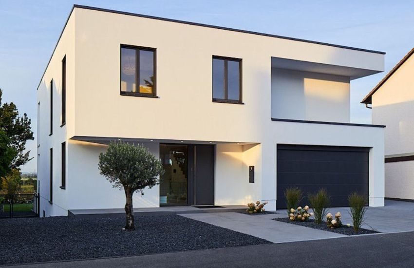 Maison moderne blanche avec garage noir, façade épurée et aménagement paysager minimaliste
